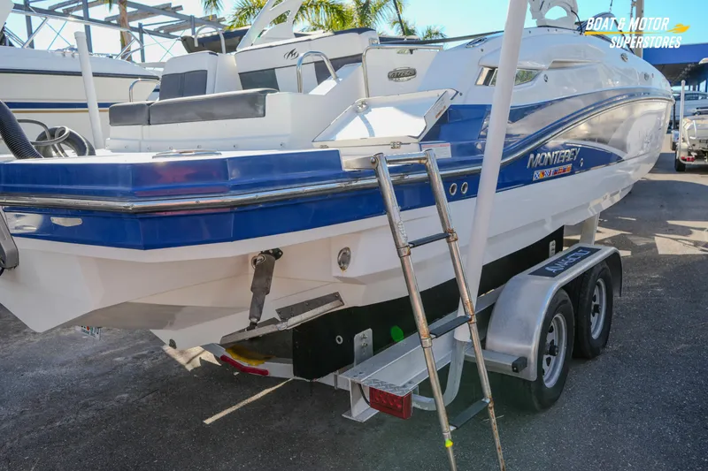 Slide: The Image of 2020 Monterey M-65 boat on trailer, featuring blue and white design with ladder. - 15