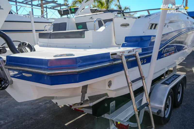 Slide: The Image of 2020 Monterey M-65 boat on trailer, featuring blue and white design with rear ladder. - 16