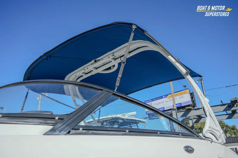 Slide: The Image of 2020 Monterey M-65 boat with blue canopy under clear sky at dealership. - 3