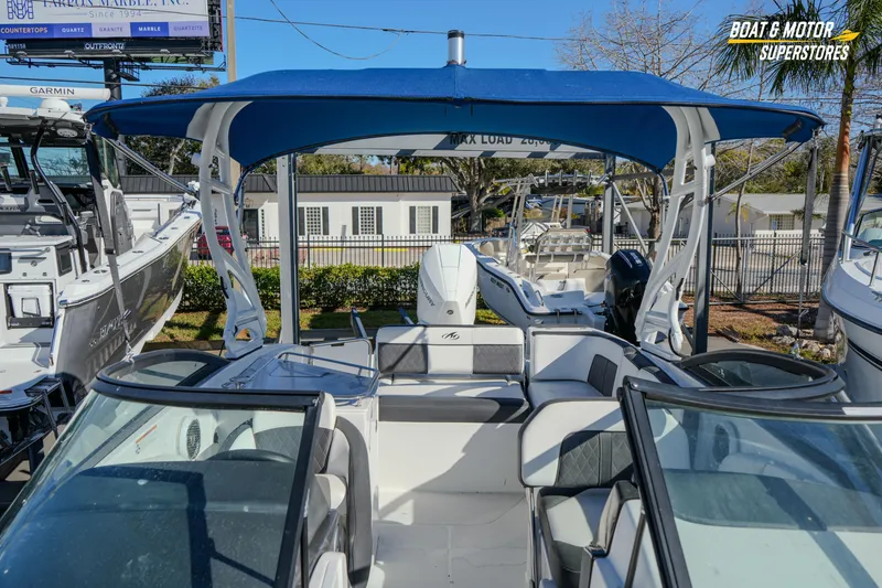 Slide: The Image of 2020 Monterey M-65 boat with blue canopy at dealership display. - 34