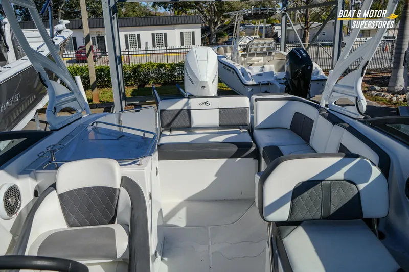 Slide: The Image of 2020 Monterey M-65 boat interior with seating and helm, displayed at a dealership. - 37