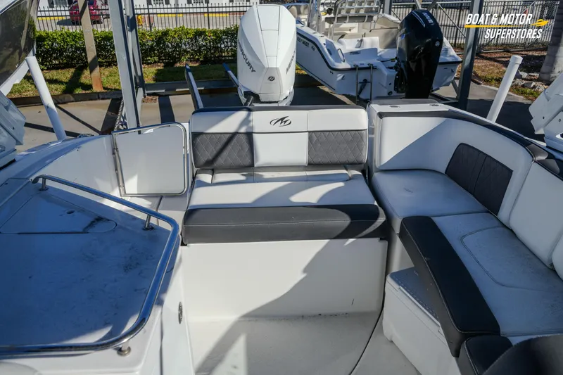 Slide: The Image of 2020 Monterey M-65 boat interior with cushioned seating and Mercury outboard motor. - 40