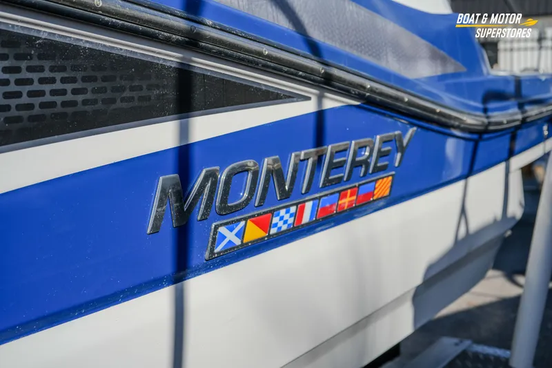 Slide: The Image of 2020 Monterey M-65 boat with vibrant blue and white design, featuring nautical flags. - 5