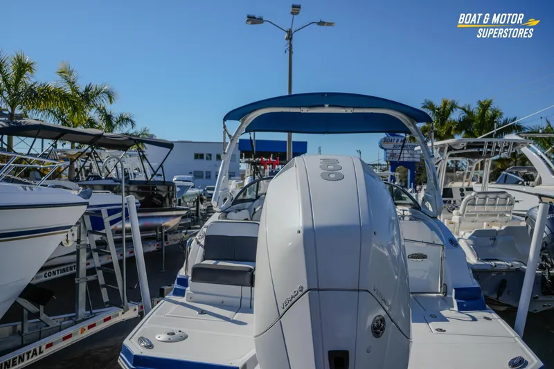 Slide: The Image of 2020 Monterey M-65 boat displayed at dealership with palm trees and clear sky. - 9