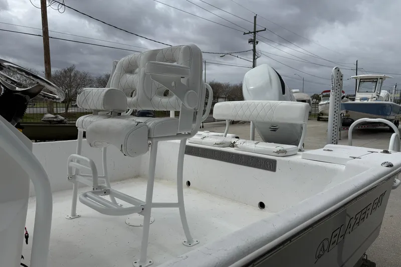 Slide: The Image of 2021 Blazer Bay 2400 boat interior with white seating and steering wheel. - 6