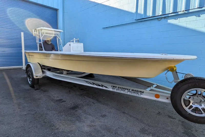 Slide: The Image of 2026 Mitzi Skiffs 17 Tournament boat on trailer, parked by blue building under sunny sky. - 3