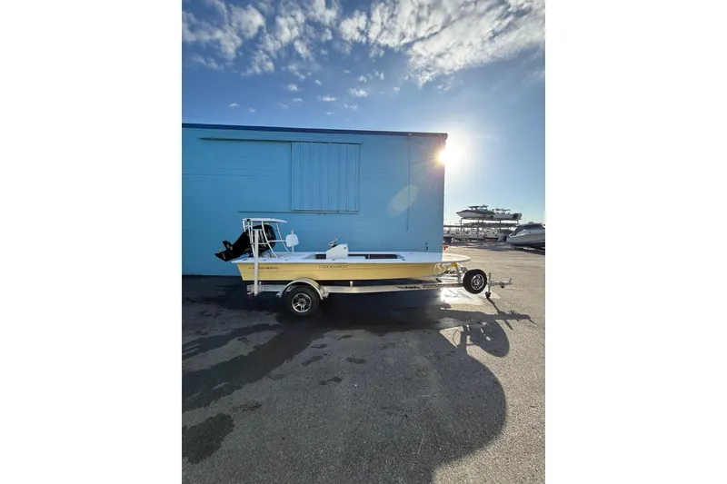Slide: The Image of 2026 Mitzi Skiffs 17 Tournament boat on trailer, parked near blue garage door. - 4