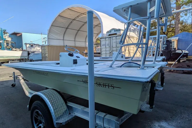Slide: The Image of 2026 Mitzi Skiffs 17 Tournament boat on trailer in marina setting. - 8
