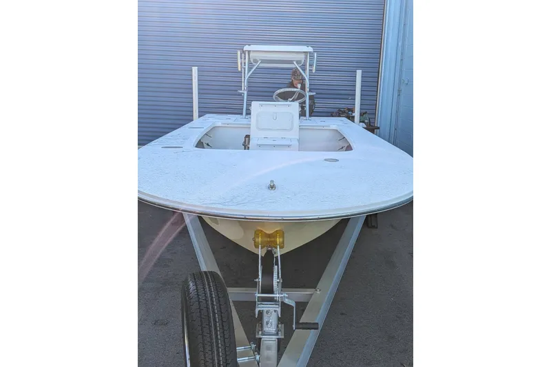 Slide: The Image of 2026 Mitzi Skiffs 17 Tournament boat on trailer, parked near blue garage door. - 9