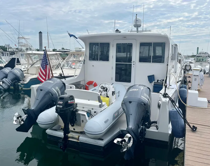 Slide: The Image of 2016 Wesmac 42 boat docked with twin outboard motors and American flag. - 5