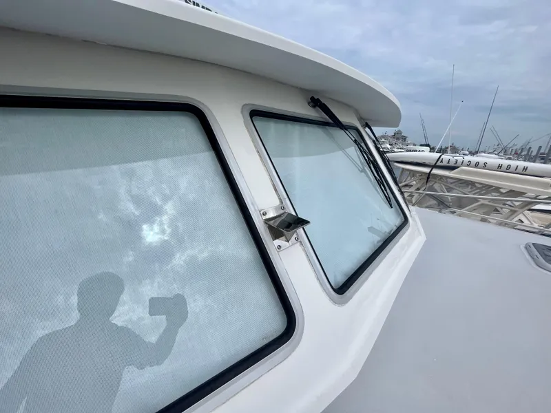 Slide: The Image of 2016 Wesmac 42 boat with large windows and docked fishing rods. - 16