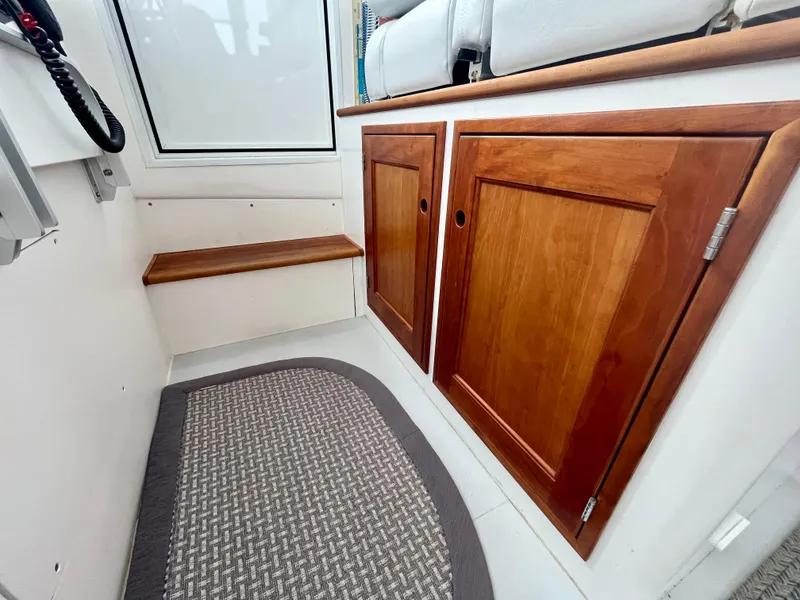 Slide: The Image of 2016 Wesmac 42 interior with wooden cabinets and a woven floor mat. - 42