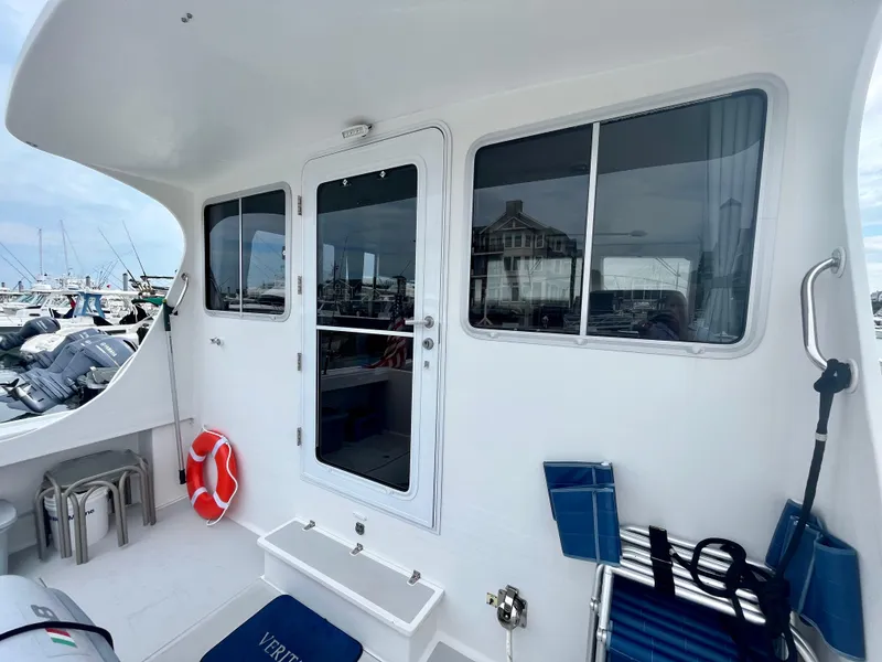 Slide: The Image of 2016 Wesmac 42 boat deck with seating, life preserver, and marina view. - 10