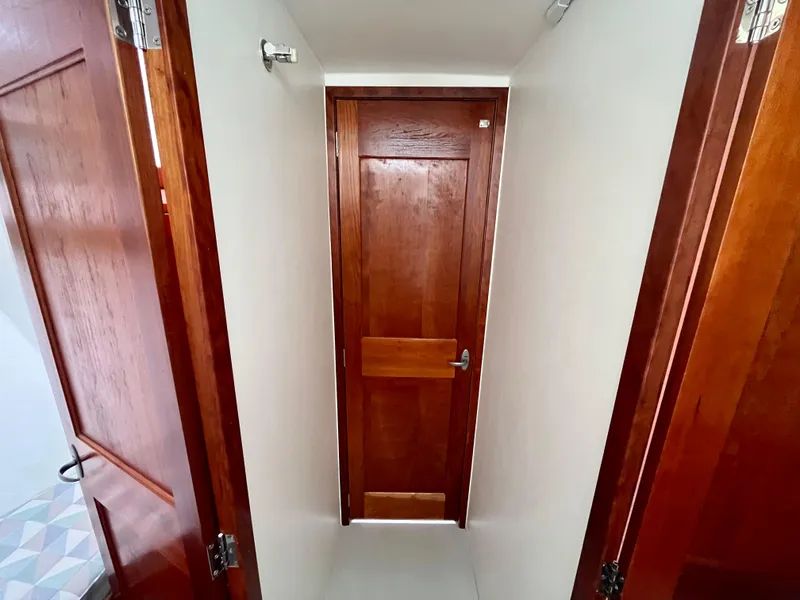 Slide: The Image of Wooden interior hallway of 2016 Wesmac 42 boat with closed door. - 43