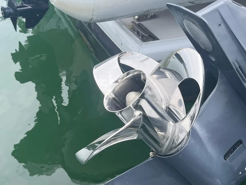Slide: The Image of Shiny boat propeller on a 2016 Wesmac 42, docked by green water. - 14