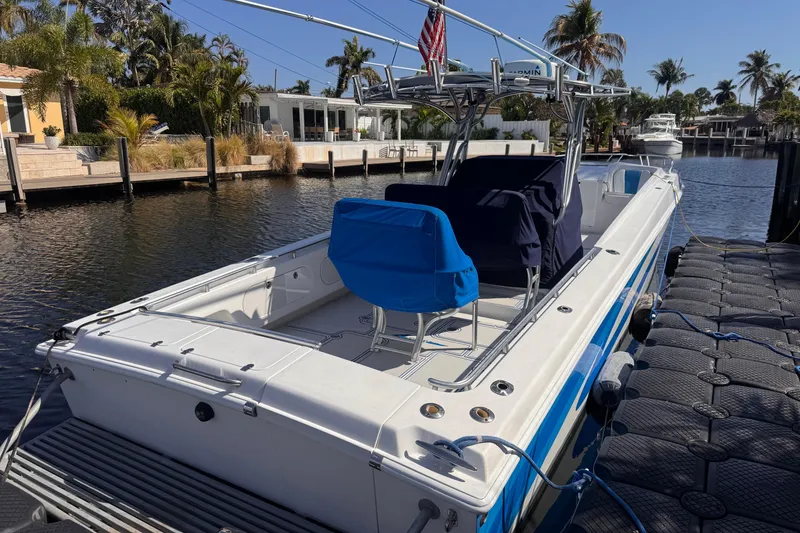 Slide: The Image of 2004 Don Smith 45 Custom boat docked by a scenic waterfront with palm trees. - 4