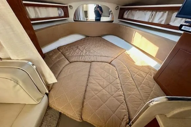 Slide: The Image of 2009 Sea Ray Sundancer 280 boat with black canopy, docked near a building. - 20