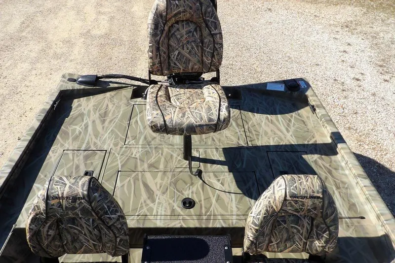 Slide: The Image of 2026 Crestliner XFC 189 boat with camouflage seating and deck, parked on gravel. - 16