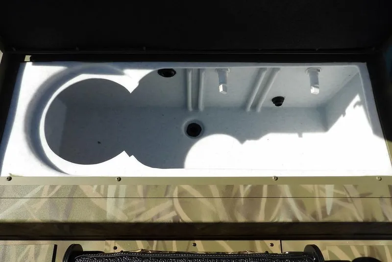 Slide: The Image of Open storage compartment in 2026 Crestliner XFC 189 boat, featuring a white interior. - 18