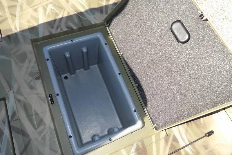 Slide: The Image of Open storage compartment in 2026 Crestliner XFC 189 boat, featuring a camo design. - 19