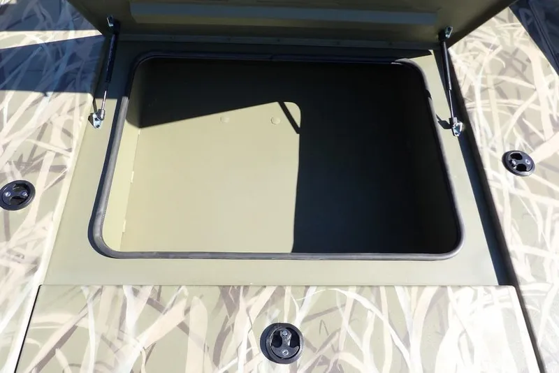 Slide: The Image of Open storage compartment on 2026 Crestliner XFC 189 boat with camo design. - 27