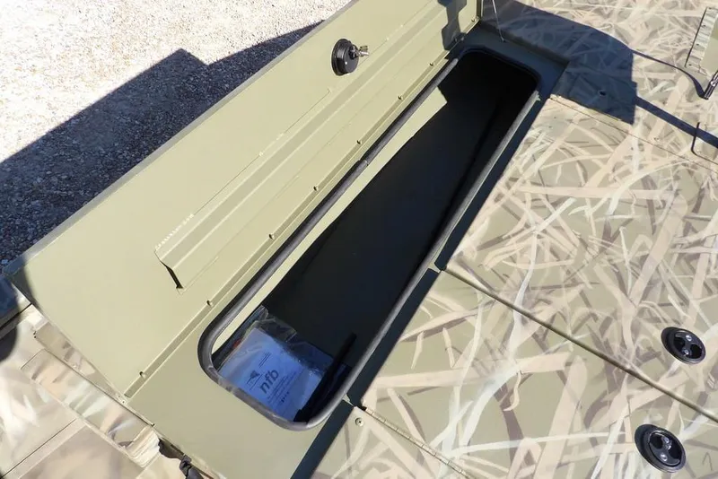 Slide: The Image of 2026 Crestliner XFC 189 boat storage compartment with camouflage design and open lid. - 28