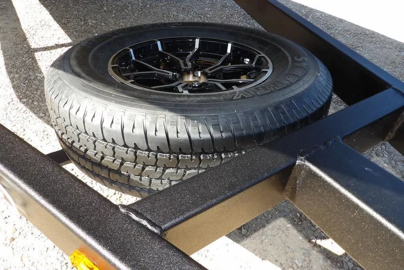 Slide: The Image of Spare tire on Crestliner XFC 189 trailer, 2026 model, on gravel surface. - 37