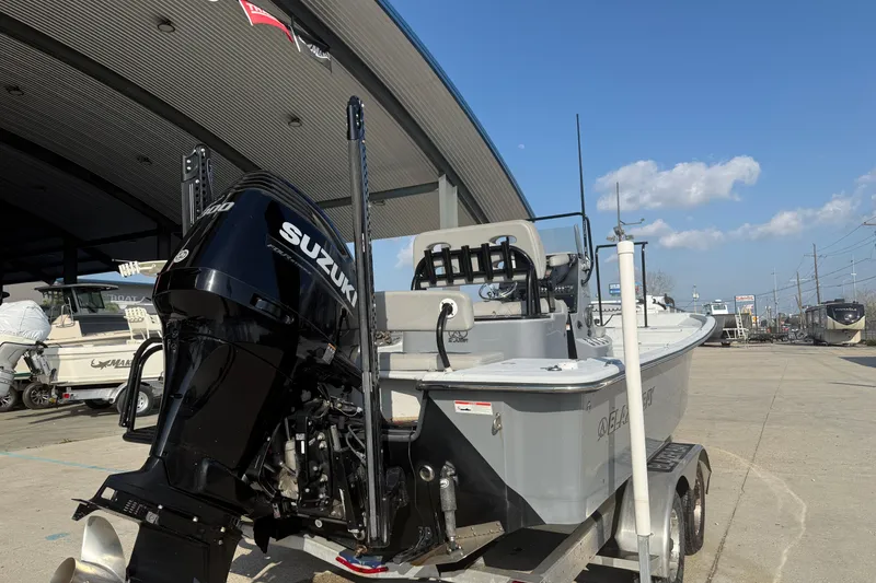 Slide: The Image of 2022 Blazer Bay 2400 boat with Suzuki engine on trailer under clear sky. - 3