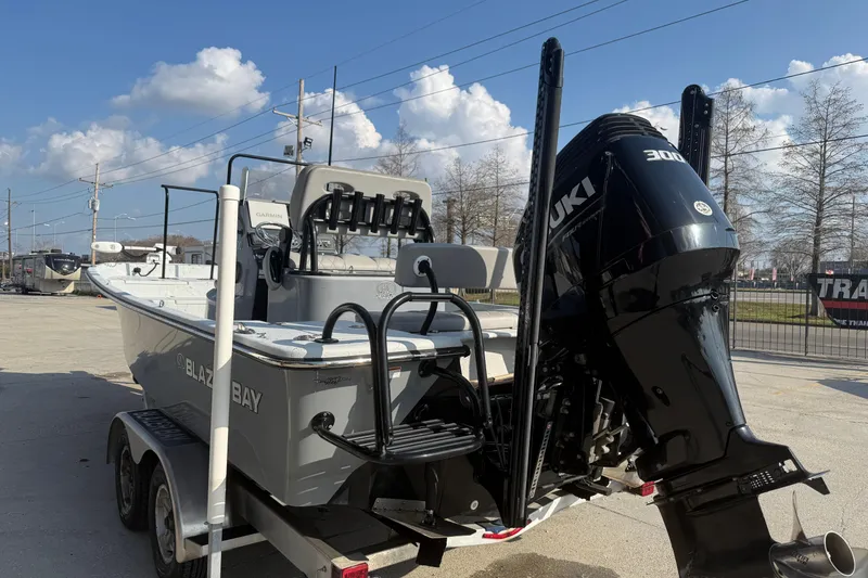 Slide: The Image of 2022 Blazer Bay 2400 boat with Suzuki 300 engine on trailer, outdoor setting. - 4