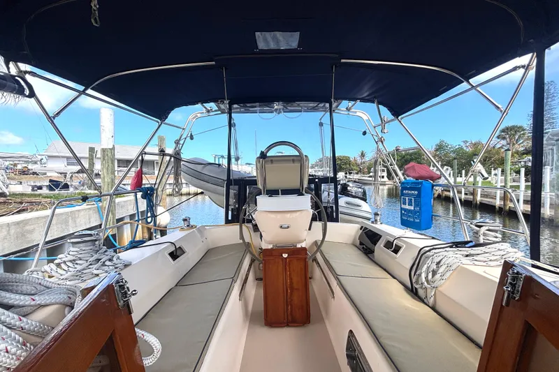 Slide: The Image of 2006 Island Packet 440 sailboat cockpit with seating, helm, and marina view. - 23