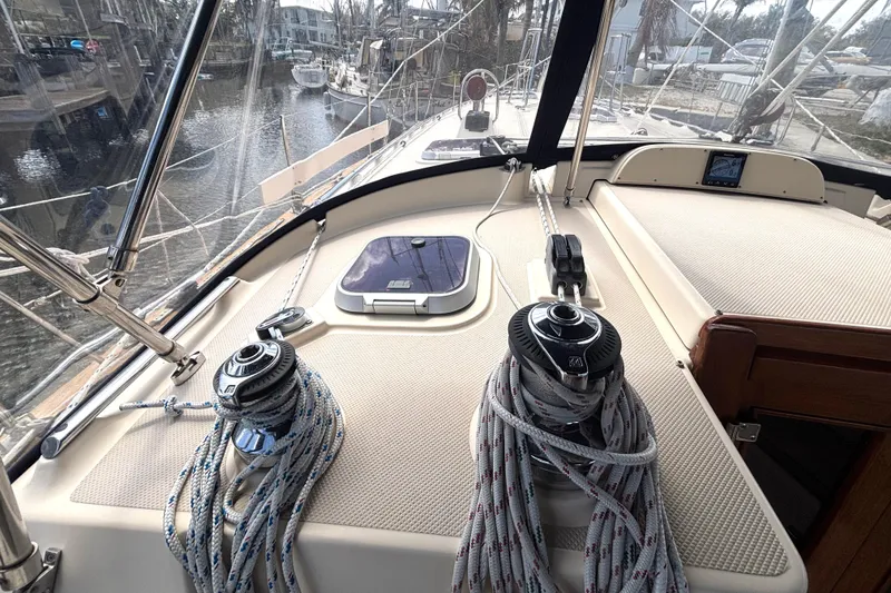 Slide: The Image of 2006 Island Packet 440 sailboat deck with winches and ropes, docked in a marina. - 24
