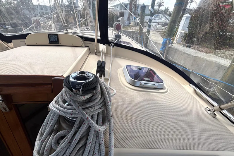 Slide: The Image of 2006 Island Packet 440 sailboat deck with winch and coiled rope, docked at marina. - 25