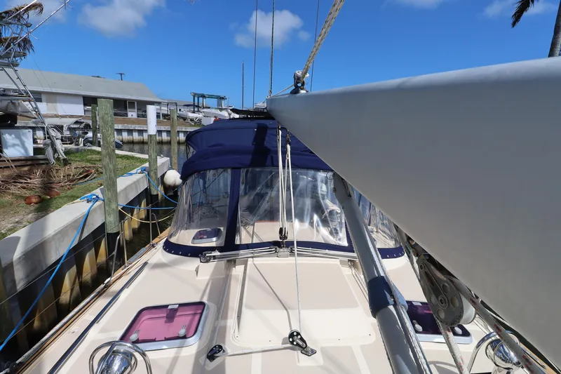 Slide: The Image of 2006 Island Packet 440 sailboat docked, featuring a blue canopy and clear skies. - 35