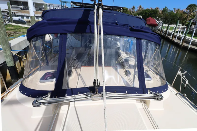 Slide: The Image of 2006 Island Packet 440 sailboat with blue canvas enclosure docked at marina. - 37