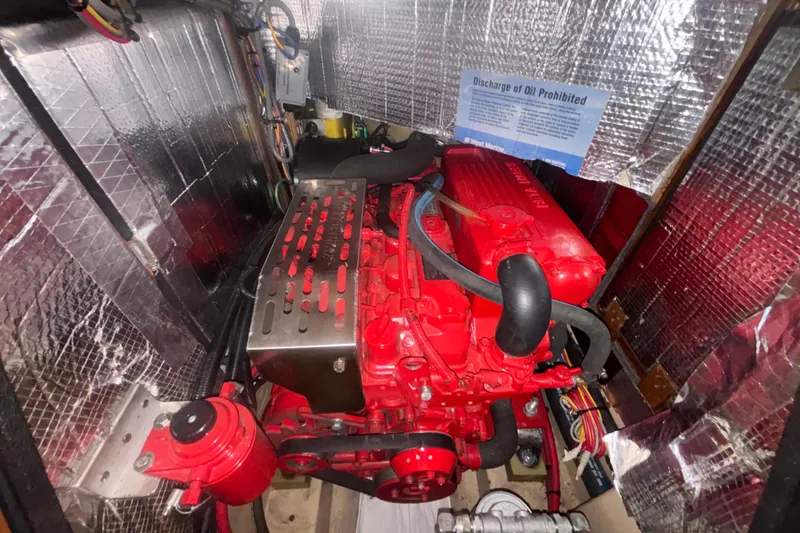 Slide: The Image of Engine compartment of a 2006 Island Packet 440 sailboat, featuring a red marine engine. - 40