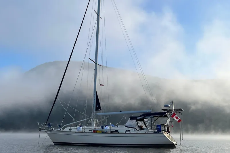 Slide: The Image of Sailboat Island Packet 440 (2006) on misty water with Canadian flag, mountain backdrop. - 42