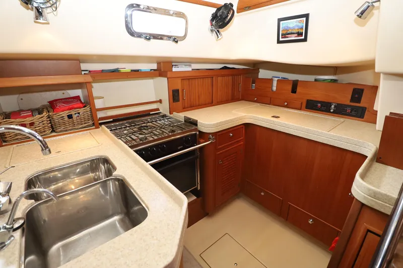 Slide: The Image of Luxurious 2006 Island Packet 440 yacht kitchen with modern amenities and wooden cabinetry. - 9