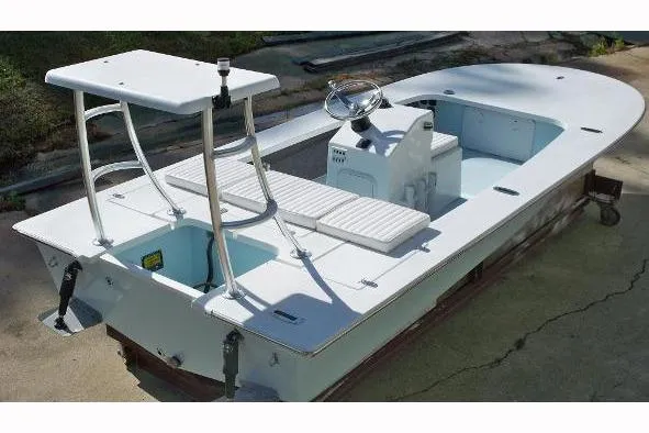 Slide: The Image of 2026 Mitzi Skiffs 17 Tournament boat, rear view with motor, parked outdoors. - 3