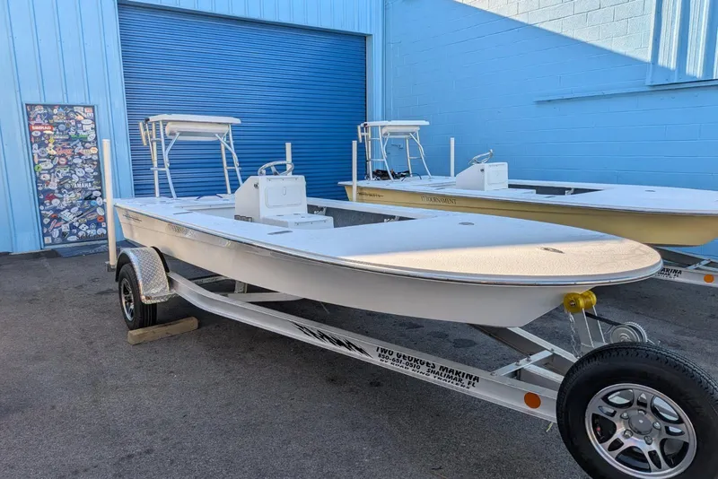 Slide: The Image of 2026 Mitzi Skiffs 17 Tournament boat with white cushioned seating and Mercury engine. - 5