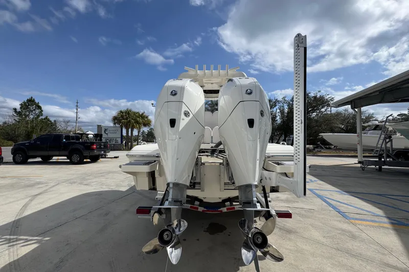 Slide: The Image of 2026 ShearWater 270 SS Open Carolina boat with dual outboard motors in a parking lot. - 12