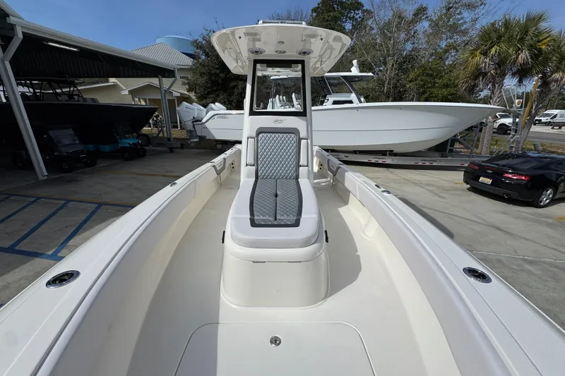 Slide: The Image of 2026 ShearWater 270 SS Open Carolina boat, sleek design, spacious deck, parked outdoors. - 23