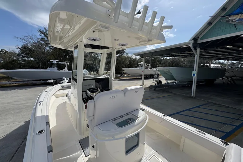Slide: The Image of 2026 ShearWater 270 SS Open Carolina boat docked, featuring modern helm and seating. - 38