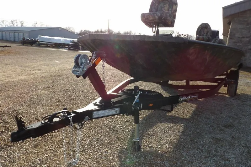 Slide: The Image of 2026 Crestliner XF 189 boat on trailer, parked outdoors, featuring camouflage seats. - 32