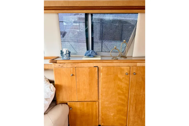 Slide: The Image of Interior of 1996 Carver 500 Cockpit Motor Yacht with wooden cabinets and decorative items. - 17