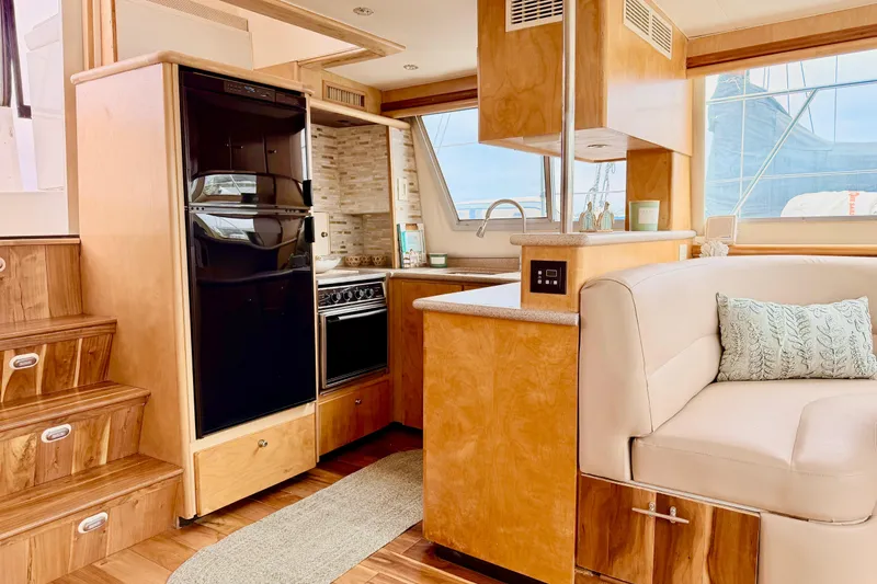 Slide: The Image of Interior of 1996 Carver 500 Cockpit Motor Yacht with modern kitchen and seating area. - 19