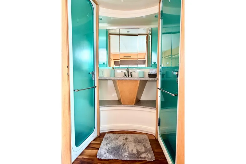 Slide: The Image of Luxurious bathroom in 1996 Carver 500 Cockpit Motor Yacht with modern fixtures and teal accents. - 24
