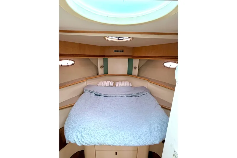 Slide: The Image of 1996 Carver 500 Cockpit Motor Yacht bedroom with cozy bed and porthole windows. - 29