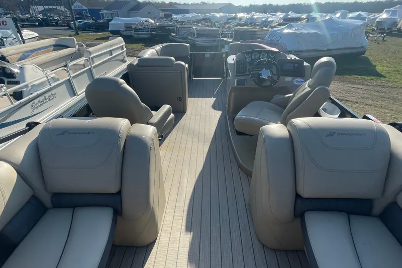 Slide: The Image of 2019 Starcraft SLS 3 pontoon boat interior with beige seating and steering console. - 10