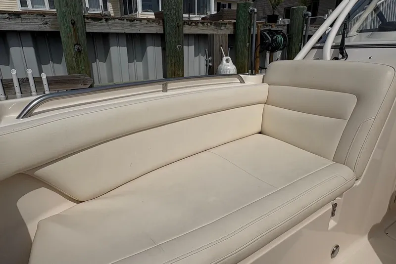 Slide: The Image of 2019 Grady-White Freedom 275 boat with beige seating, docked by wooden posts. - 15