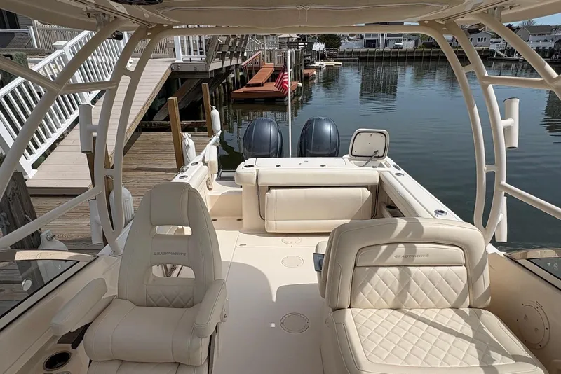 Slide: The Image of 2019 Grady-White Freedom 275 boat interior with luxurious seating and dual engines at dock. - 16